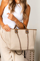 Bisque structured canvas tote with silver chain strap and top handles, styled with neutral outfit
