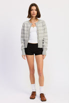 Model wearing grey and white striped button cardigan with white tank underneath
