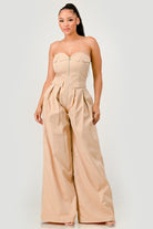 Beige strapless jumpsuit with zipper front and pleated wide-leg pants
