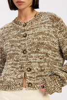 Close-up of taupe marled knit sweater showing button-front texture detail
