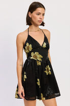 Side view of black halter mini dress with gold floral accents
