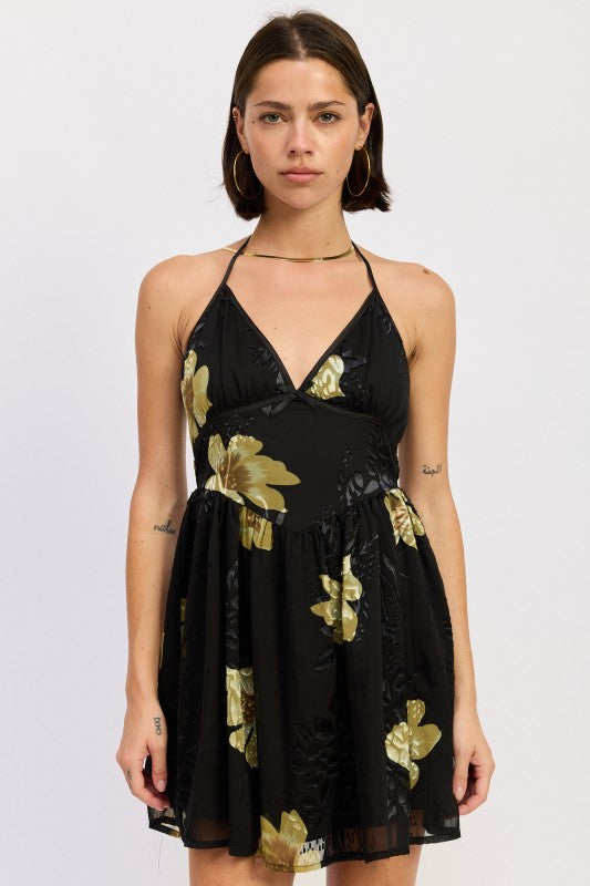 Front view of black and gold floral halter mini dress on model
