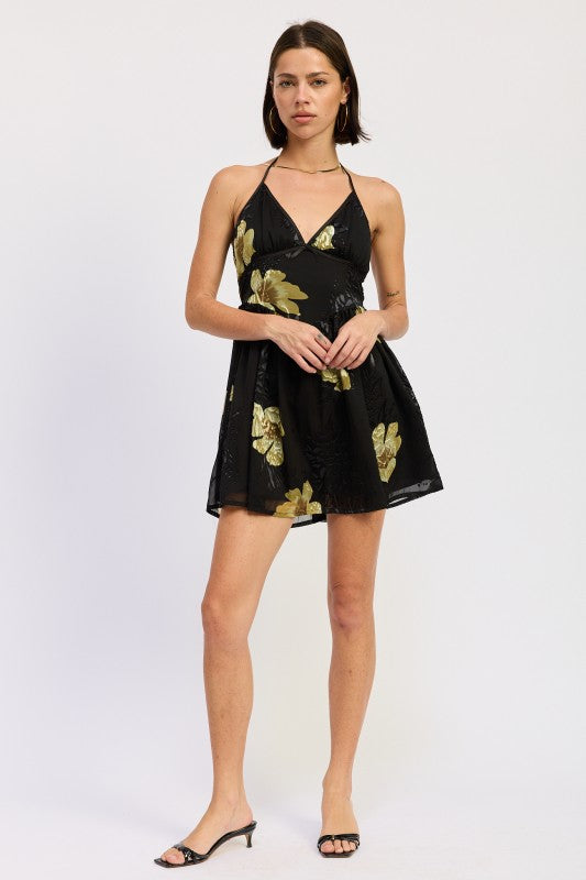 Full-length view of black floral halter mini dress with flowy skirt

