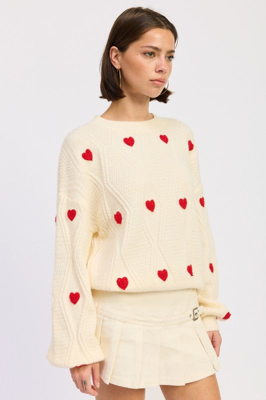 Textured ivory sweater with red heart accents and crew neckline