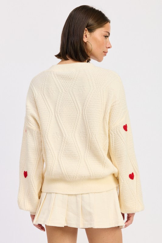 Back view of ivory knit sweater showing textured pattern and relaxed silhouette