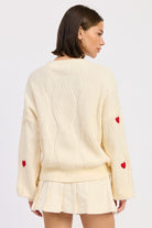 Back view of ivory knit sweater showing textured pattern and relaxed silhouette