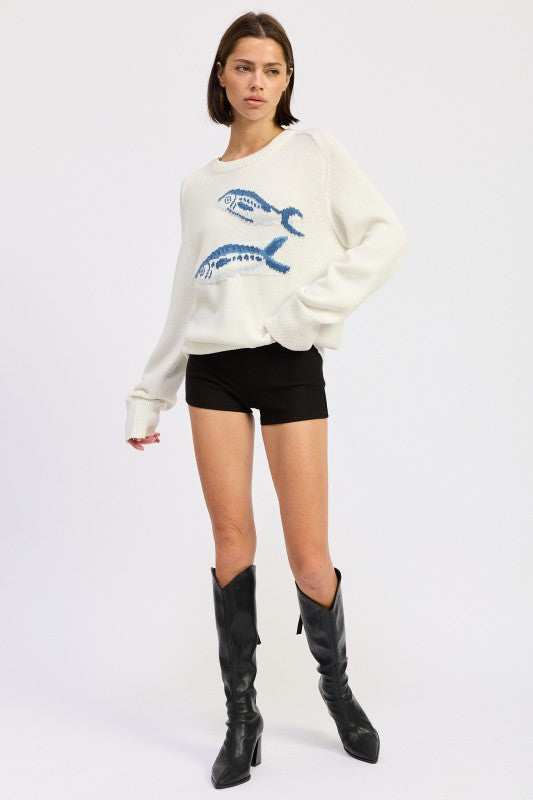 Full-length view of fish graphic knit sweater styled with black shorts and boots
