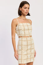 Three-quarter front view of cream crochet mini dress with thin straps.
