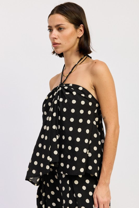Side view of black polka dot halter top with relaxed drape
