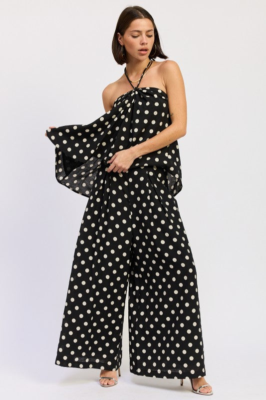 Black polka dot halter top styled with matching pants, movement detail
