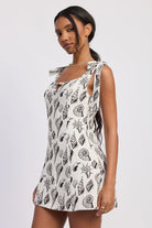 Side profile of the seashell mini dress highlighting fitted bodice and adjustable tie straps.