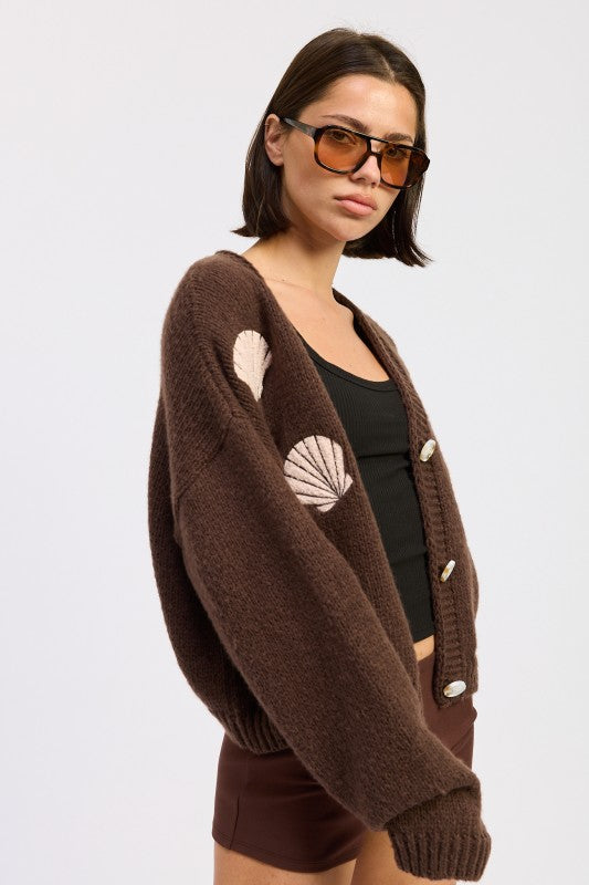 Side view of mocha seashell cardigan highlighting oversized sleeves and textured knit.
