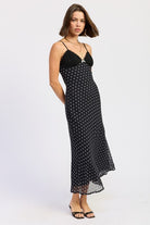 Side view of black polka dot slip dress with lace bust and fitted silhouette.
