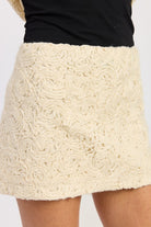 Close-up of Ivory Reverie Textured Mini Skirt fabric showing swirl knit texture and soft acrylic finish.