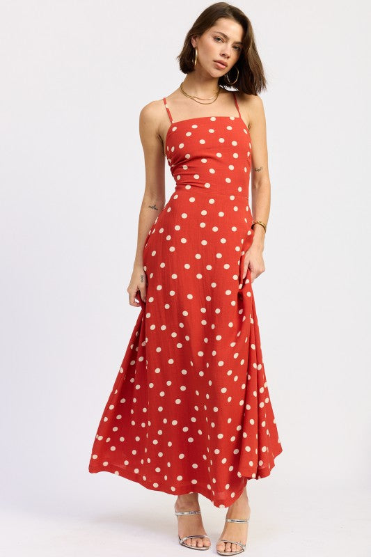 Model wearing a red polka dot maxi dress with a straight neckline and thin straps.
