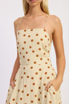 Butter cream polka dot dress showing pockets and flowy fit.