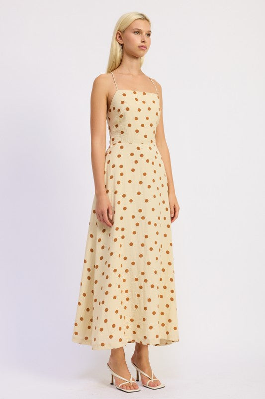 Side profile of the butter cream polka dot maxi with fitted bodice and flared skirt.