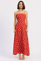 Model wearing a red polka dot maxi dress with a straight neckline and thin straps - AVAH