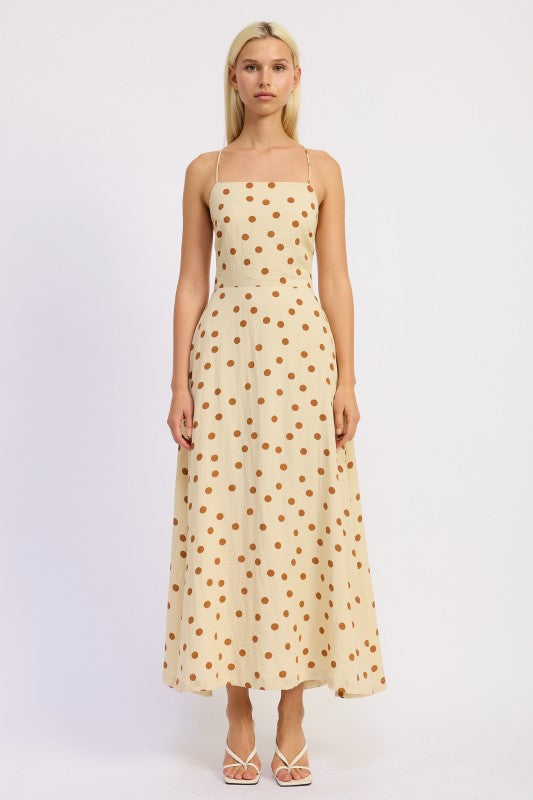 Model wearing a butter cream maxi dress with caramel polka dots and a straight neckline - AVAH