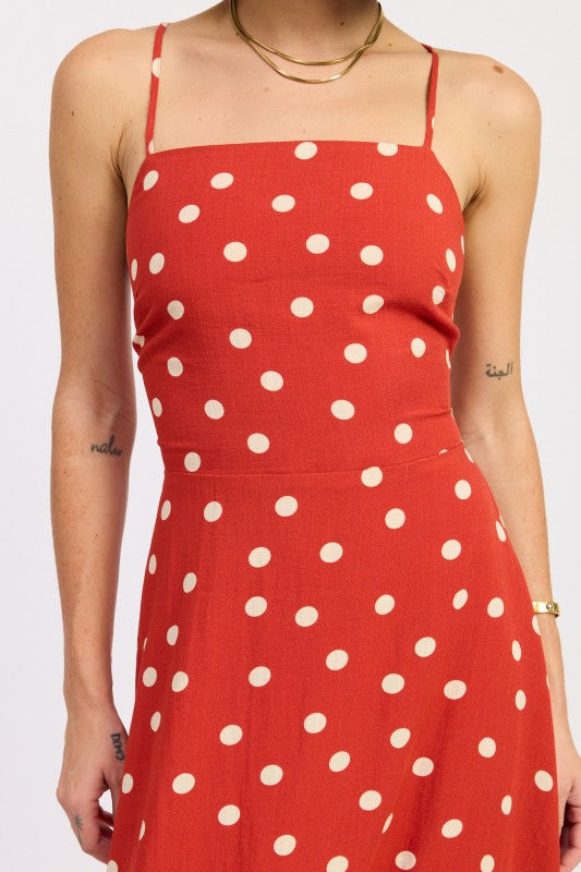 Close view of the red dress showing the straight neckline and cream polka dots.