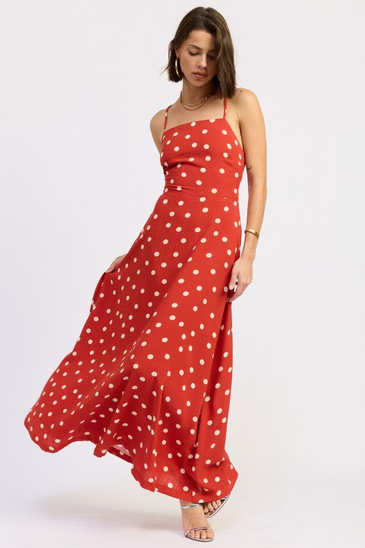 Model in red polka dot maxi dress mid-twirl showing skirt flow.