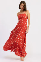 Model in red polka dot maxi dress mid-twirl showing skirt flow.
