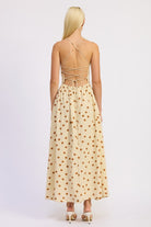 Model wearing the butter cream polka dot dress with open lace-up back and criss-cross ties.
