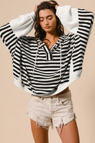 Oversized black and white striped hoodie with contrast knit sleeves and casual cropped length