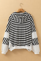 Back view of black and white striped hooded pullover showing relaxed fit, hood detail, and contrast knit hem