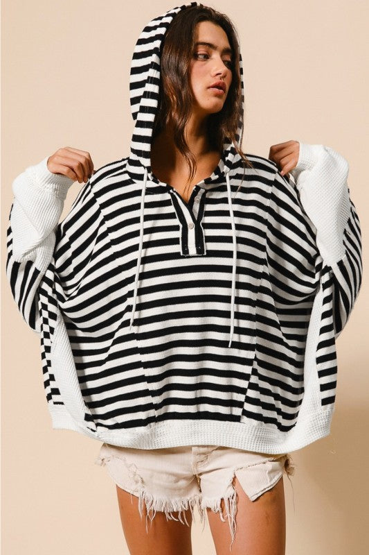 Black and white striped hooded pullover with drawstring hood and button neckline in a relaxed silhouette