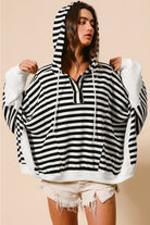 Black and white striped hooded pullover with drawstring hood and button neckline in a relaxed silhouette