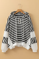 Black and white striped hooded pullover top on hanger with button neckline, drawstrings, and contrast sleeve panels