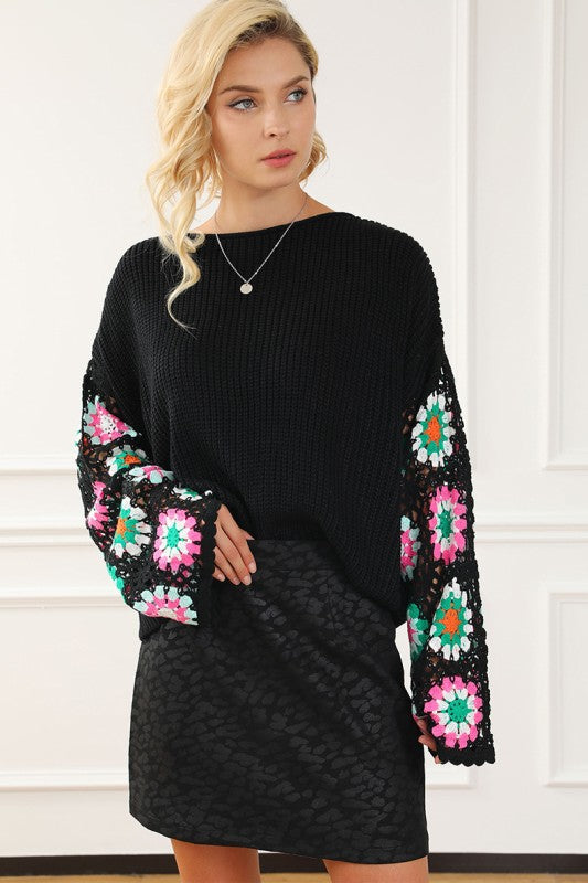 Black sweater with statement crochet sleeves styled with mini skirt