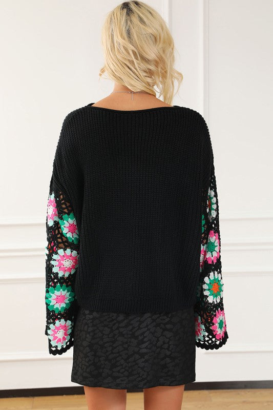 Back view of black knit sweater with crochet sleeve detailing

