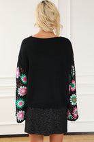 Back view of black knit sweater with crochet sleeve detailing

