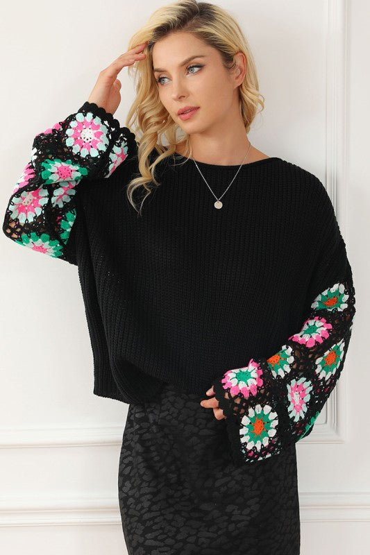 Black knit sweater with colorful crochet floral sleeves, front view
