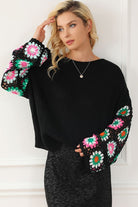 Black knit sweater with colorful crochet floral sleeves, front view