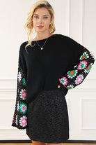 Black knit sweater with colorful crochet floral sleeves, front view