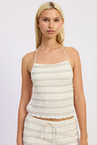Front view of cream textured halter top with ruffle detailing and matching maxi skirt
