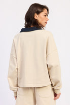 Back view of ivory long sleeve collared cotton top with clean lines and relaxed fit
