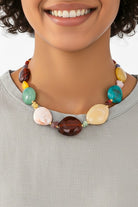 Multicolor marbled resin bead statement necklace worn with white sleeveless top
