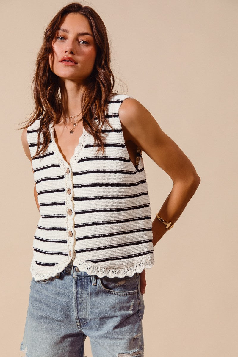 Woman wearing cream and black striped knit vest with crochet trim
