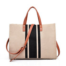 Beige canvas tote bag with black and white stripes and brown leather straps on a white background