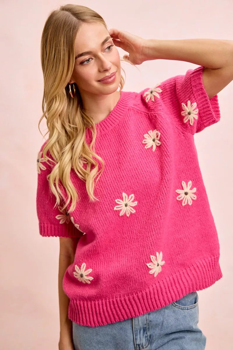 Pink daisy embroidered short sleeve sweater with crew neckline and ribbed trim
