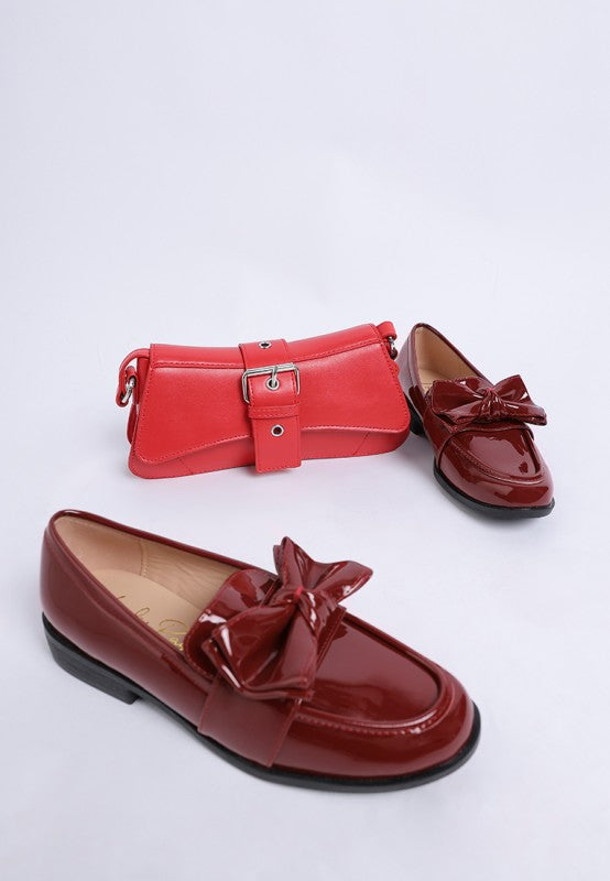 red bow loafers styled with small red handbag
