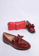 red bow loafers styled with small red handbag
