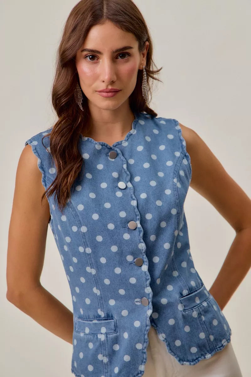 Woman styling tailored polka dot denim vest with white pants
