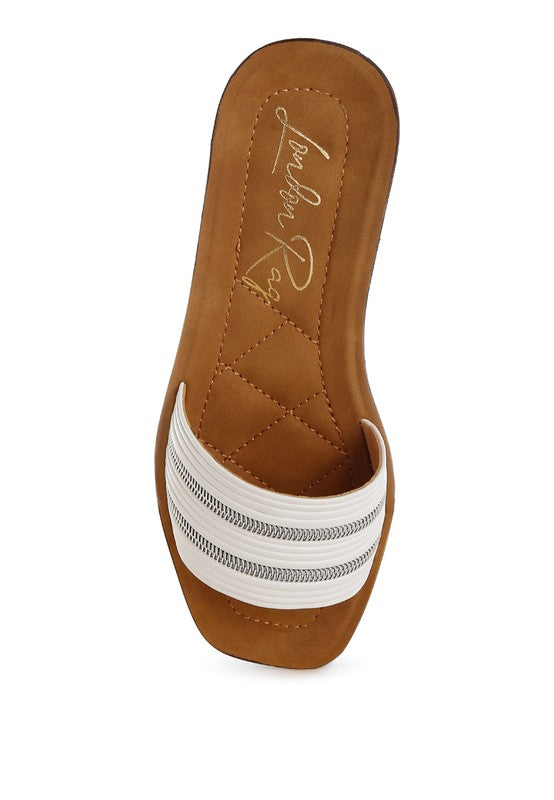 Overhead view of white slides showcasing square open toe and soft insole.