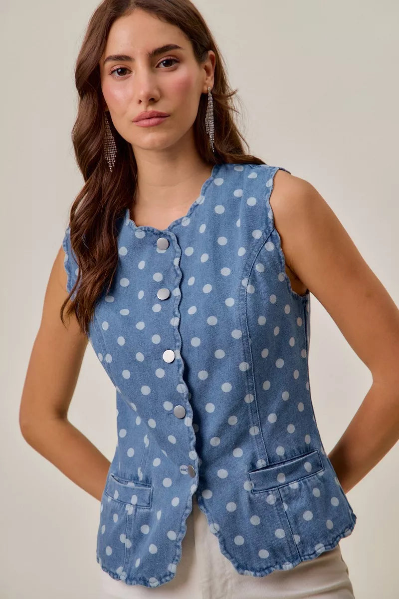 Woman wearing blue polka dot denim vest top with scalloped trim
