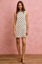 textured bow pattern mini dress full length front view with pearl button embellishments.
